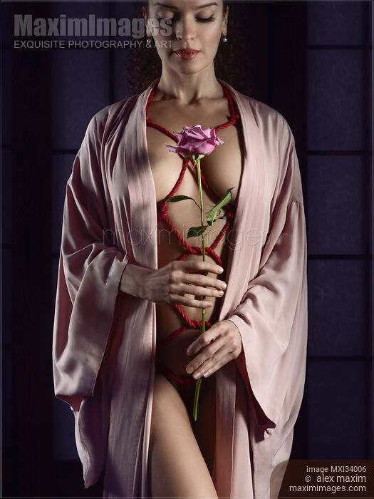 Woman with red ropes of Shibari bondage tied around her sensual naked body holding pink rose Stock photo of Woman with red ropes of Shibari bondage tied around her sensual naked body holding pink rose Buy commercial use license at MaximImages