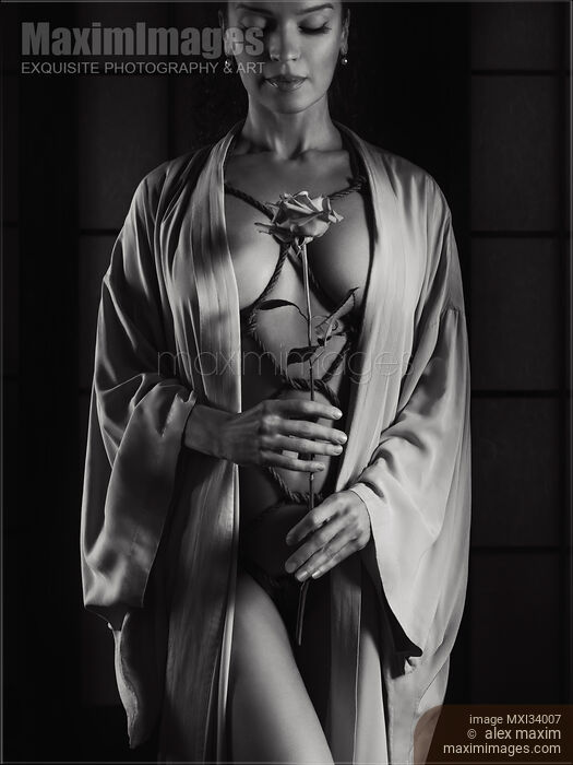 Stock photo of Woman with ropes of Shibari bondage tied around her sensual naked body holding a rose Art nude black and white Buy commercial use license at MaximImages