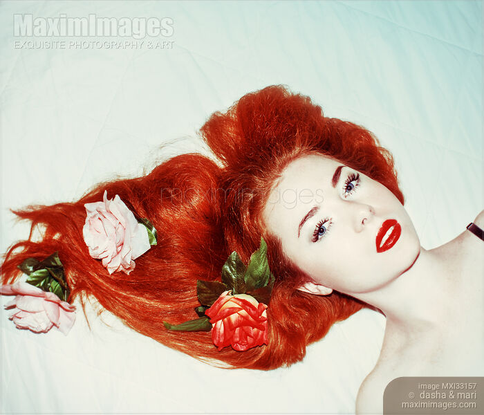 Woman with white skin, red lips and roses in her bright red hair on white Stock photo of Woman with white skin, red lips and roses in her bright red hair on white Buy commercial use license at MaximImages