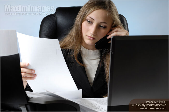 Stock photo of Young businesswoman or female student in the office doing paperwork Buy commercial use license at MaximImages