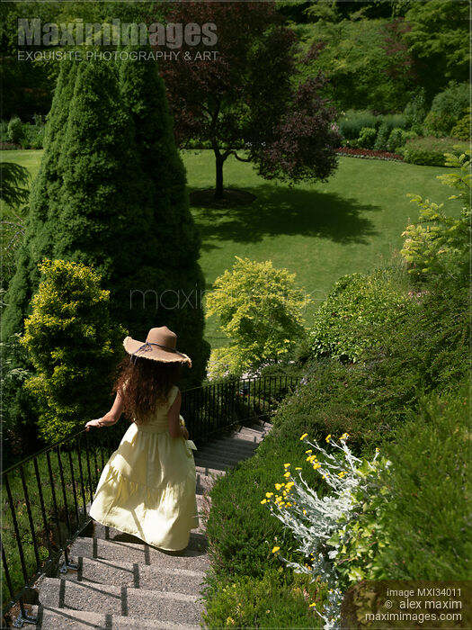 Young lady in summer dress and sun hat running down the staircase of a green garden Stock photo of Young lady in summer dress and sun hat running down the staircase of a green garden Buy commercial use license at MaximImages