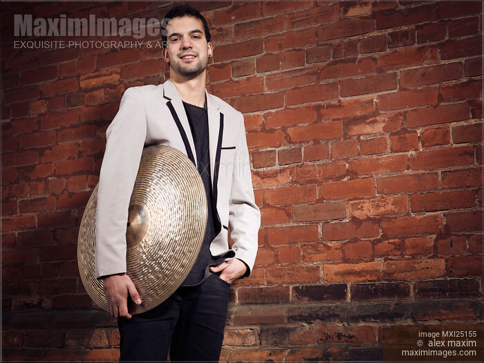 Stock photo of Young man drummer with a cymbal Buy commercial use license at MaximImages
