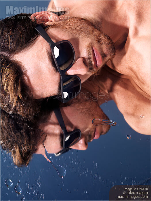 Stock photo of Young man in sunglasses lying in the sun Buy commercial use license at MaximImages