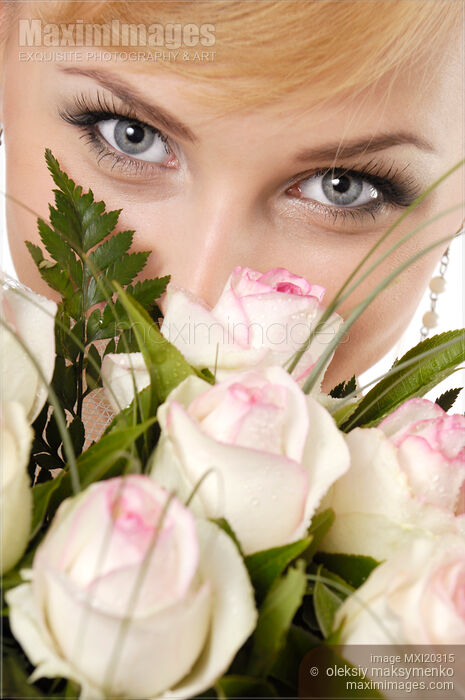 Stock photo of Young Smiling Woman Eyes over Bunch of White Roses Buy commercial use license at MaximImages
