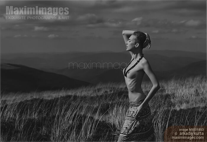 Stock photo of Young tribal woman standing topless in an open field Buy commercial use license at MaximImages