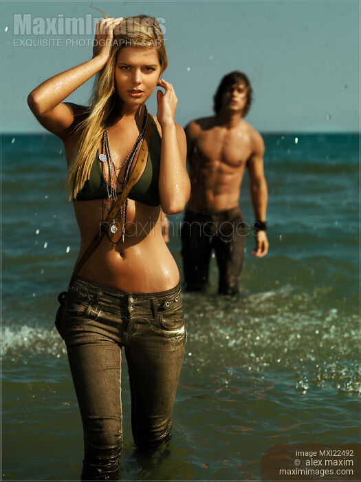 Young Woman and a Young Man Walking Out of Water Stock photo of Young Woman and a Young Man Walking Out of Water Buy commercial use license at MaximImages