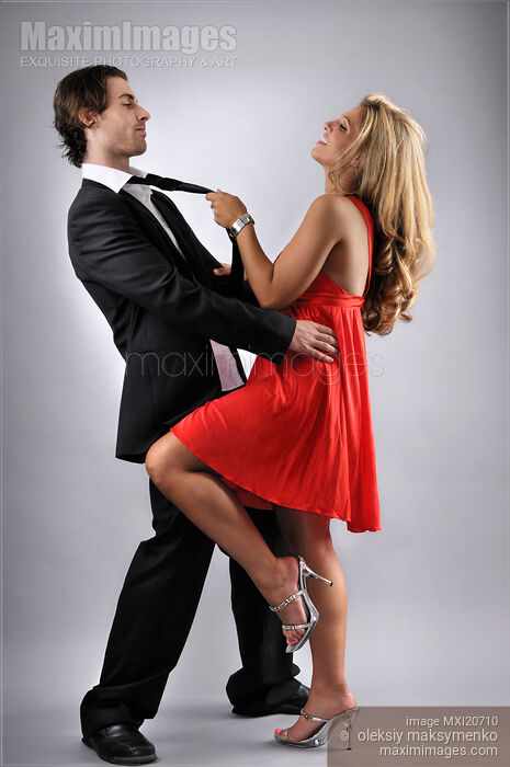 Young Woman Flirting with a Man pulling him by the tie Stock photo of Young Woman Flirting with a Man pulling him by the tie Buy commercial use license at MaximImages