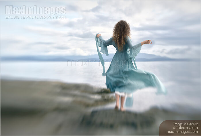 Young woman in a long dress running towards sea shore Rear view Stock photo of Young woman in a long dress running towards sea shore Rear view Buy commercial use license at MaximImages