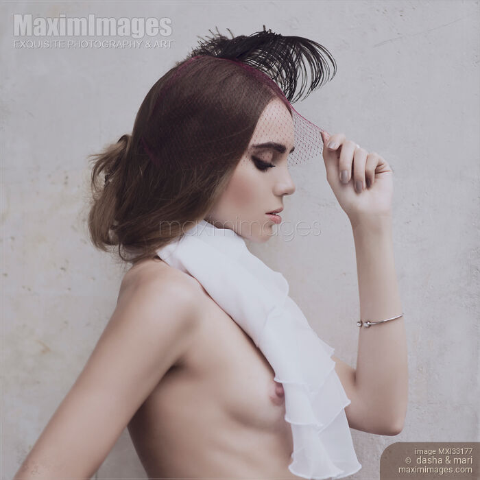 Young woman in a veil headpiece with a feathers and a white scarf barely covering her naked breast Sensual vintage portrait Stock photo of Young woman in a veil headpiece with a feathers and a white scarf barely covering her naked breast Sensual vintage portrait Buy commercial use license at MaximImages