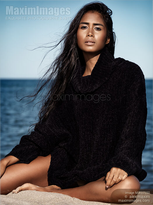 Young woman in sweater sitting at the beach Stock photo of Young woman in sweater sitting at the beach Buy commercial use license at MaximImages