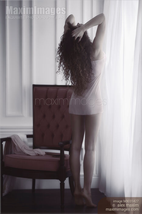 Young woman in underwear with bare legs standing on tiptoes stretching by the window in morning sunlight Stock photo of Young woman in underwear with bare legs standing on tiptoes stretching by the window in morning sunlight Buy commercial use license at MaximImages