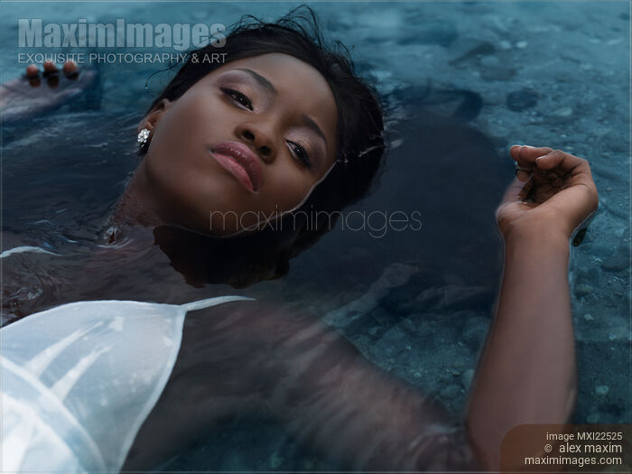 Young Woman in White Dress Lying in Water Stock photo of Young Woman in White Dress Lying in Water Buy commercial use license at MaximImages