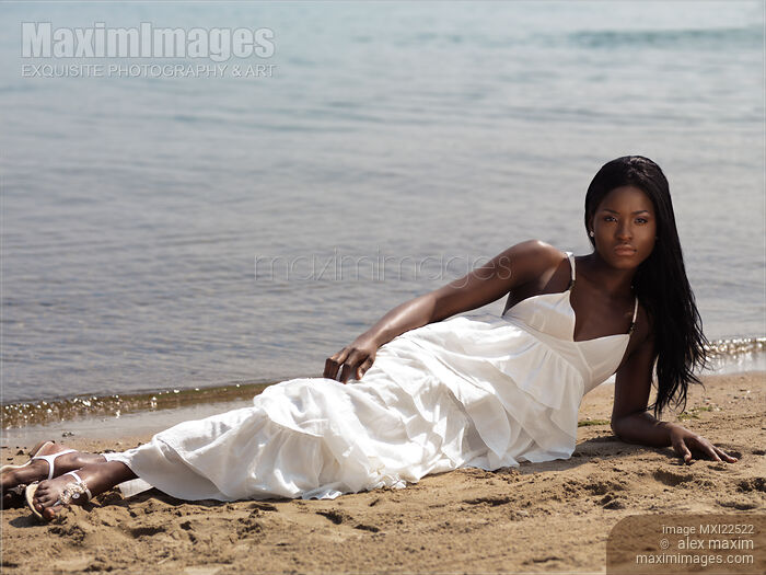 Stock photo of Young Woman In White Dress on the Beach Buy commercial use license at MaximImages