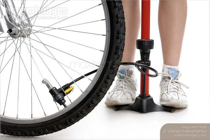 Stock photo of Young Woman Inflating Bicycle Tire Buy commercial use license at MaximImages