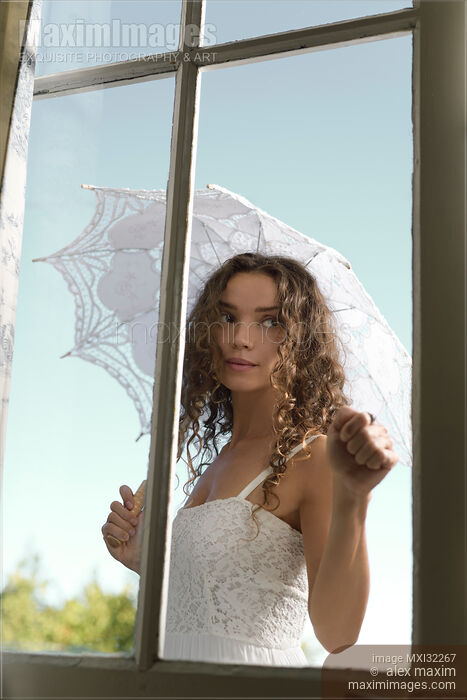 Young woman knocking on the door standing outside the house in summer dress with a French lace parasol Stock photo of Young woman knocking on the door standing outside the house in summer dress with a French lace parasol Buy commercial use license at MaximImages