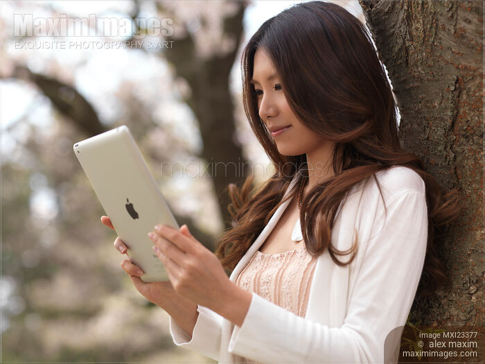 Young Woman Outdoors with iPad Stock photo of Young Woman Outdoors with iPad Buy commercial use license at MaximImages