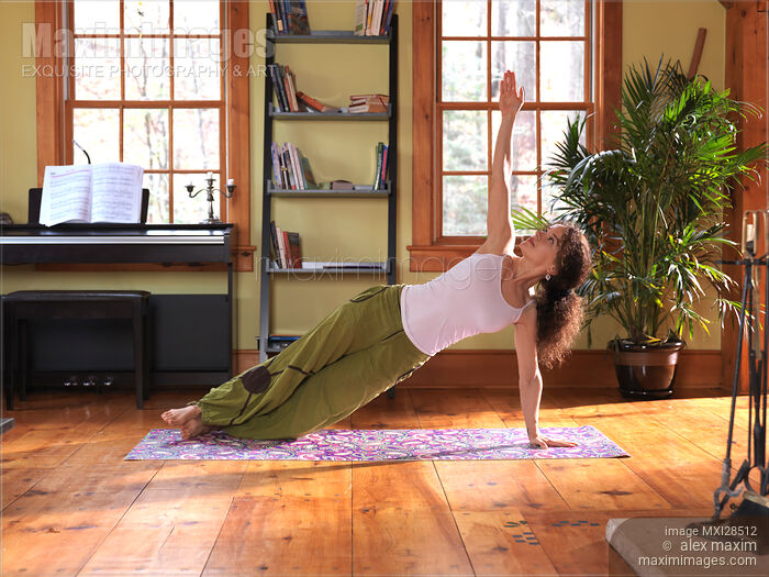 Stock photo of Young woman practicing yoga indoors Buy commercial use license at MaximImages