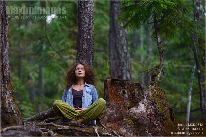 Young woman resting meditating in forest sitting against tree trunk in nature scenery Stock photo of Young woman resting meditating in forest sitting against tree trunk in nature scenery Buy commercial use license at MaximImages