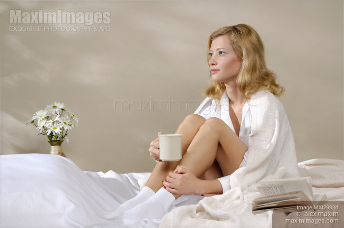 Young Woman Sitting on Bed Stock photo of Young Woman Sitting on Bed Buy commercial use license at MaximImages
