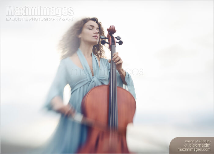 Young woman thoughtfully playing cello in a bright sunrise outdoor scenery Stock photo of Young woman thoughtfully playing cello in a bright sunrise outdoor scenery Buy commercial use license at MaximImages