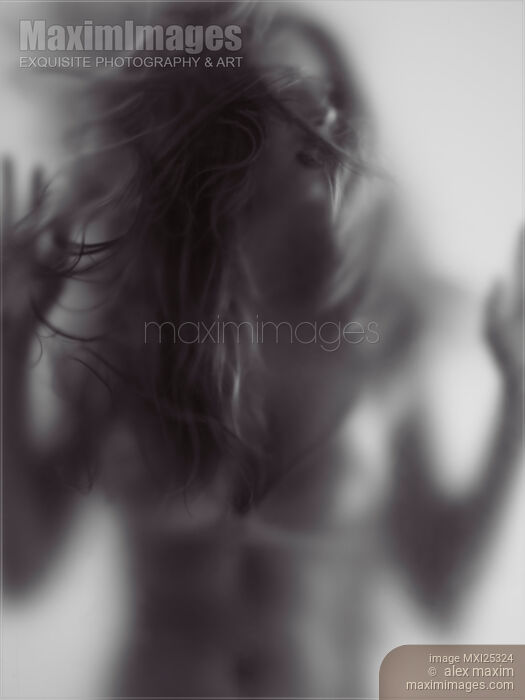 Stock photo of Young woman trapped behind glass Buy commercial use license at MaximImages