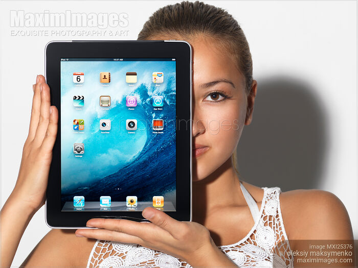 Stock photo of Young woman with Apple iPad in hands Buy commercial use license at MaximImages