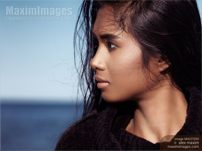 Stock photo of Young woman with dark hair portrait at the beach Buy commercial use license at MaximImages