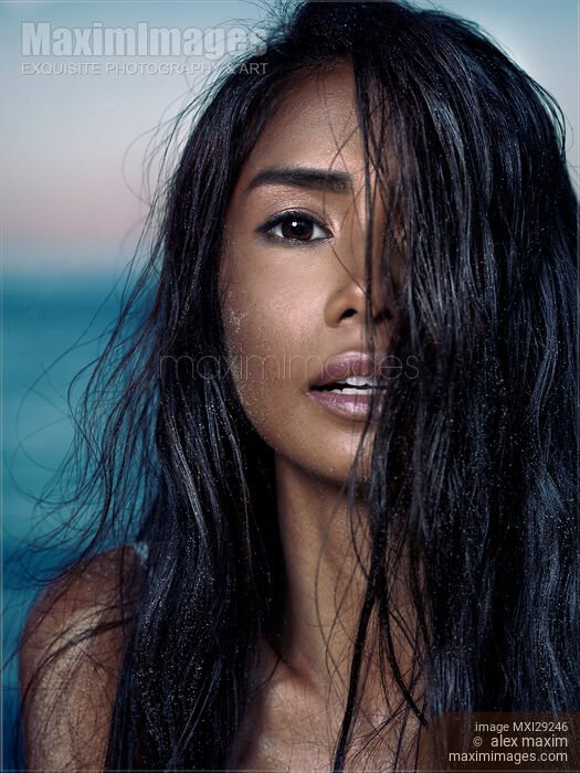 Young woman with long wet black hair covering her exotic face Stock photo of Young woman with long wet black hair covering her exotic face Buy commercial use license at MaximImages