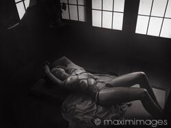 Beautiful nude woman lying on the floor tied up with red Shibari bondage ropes Sensual erotic black and white photograph